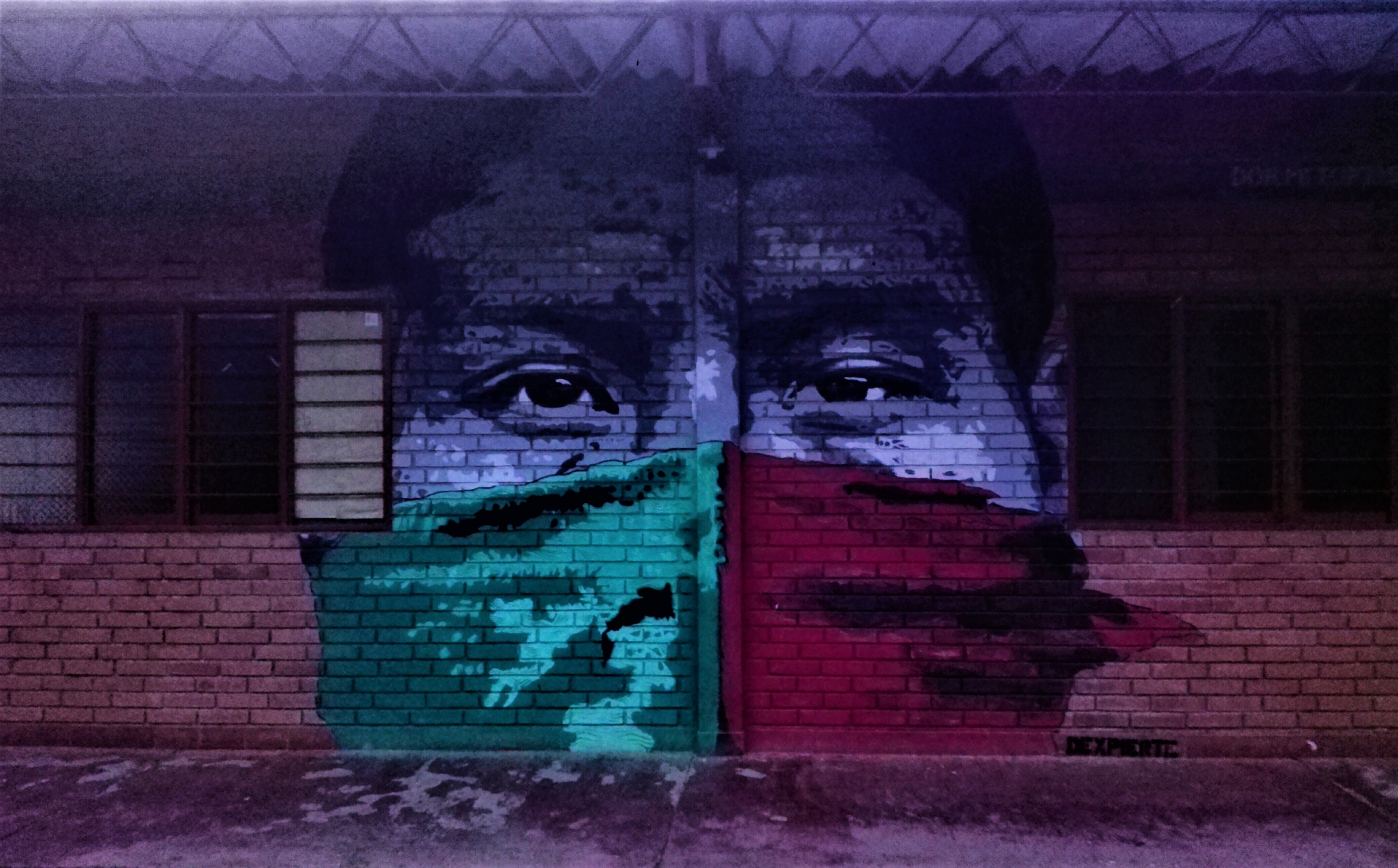 Mural di un indigeno Nasa con il viso coperto dall'immancabile fazzoletto rosso e verde, i colori simbolo della resistenza Nasa e dell'organizzazione di riferimento, il Consiglio Regionale Indigeno del Cauca - CRIC
